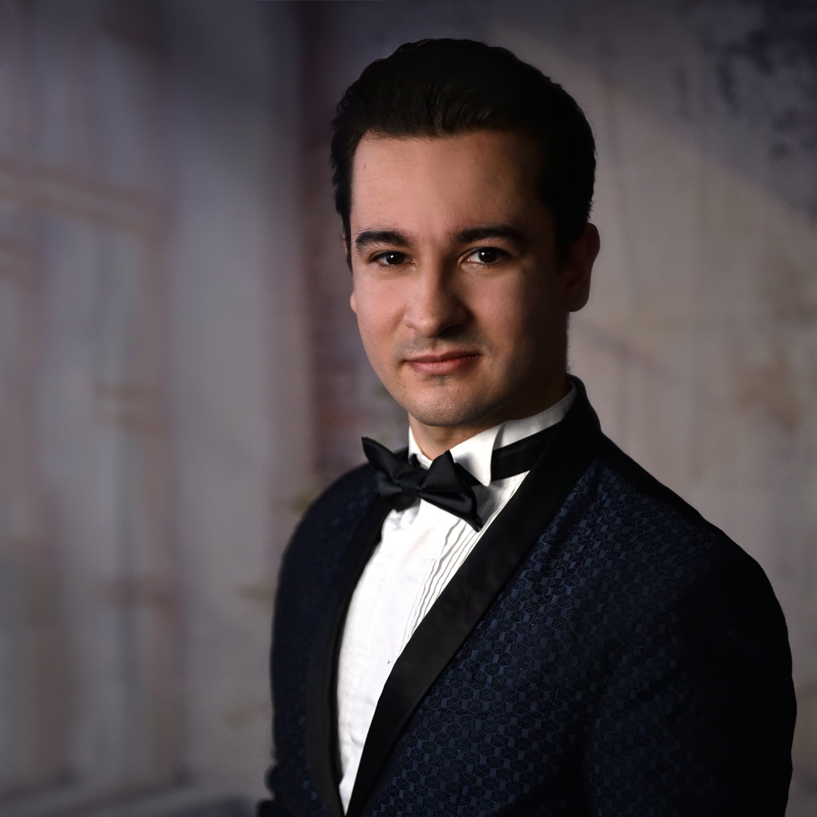 Portrait of bass-baritone Jakub Osmera in a navy dinner jacket